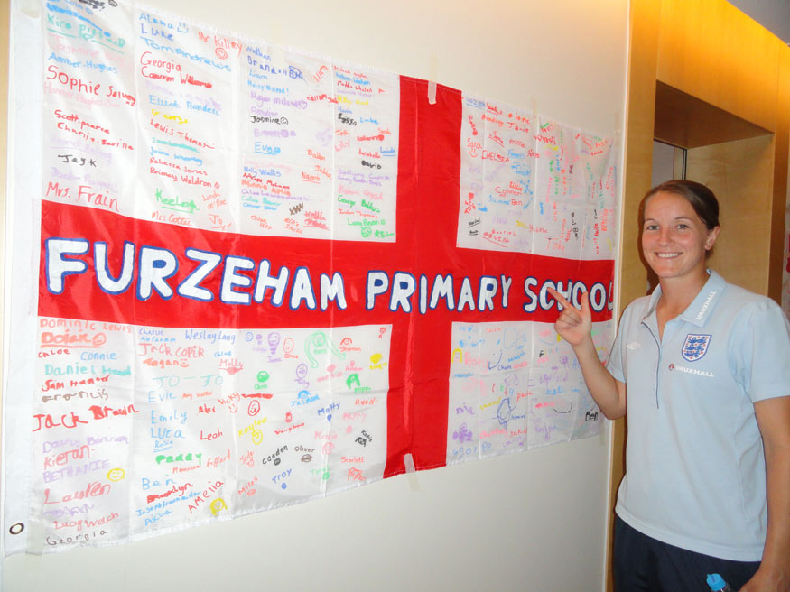 The flag sent to the World Cup by Furzeham Primary School gets Casey Stoney's approval.